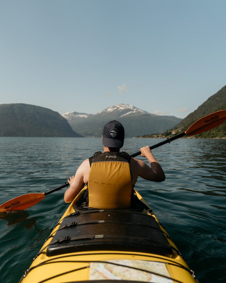 Homme en kayak devant les montagnes en Norvège.